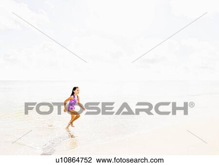 Girl (6-7) running on beach View Large Photo Image Stock Image - Girl (6-7) running on beach. Fotosearch