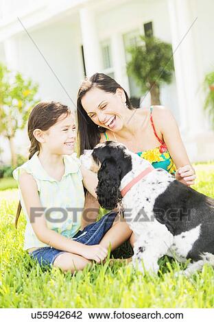 Girl (6-7) with mom and dog in backyard View Large Photo Image Stock Image - Girl (6-7) with mom and dog in backyard . Fotosearch