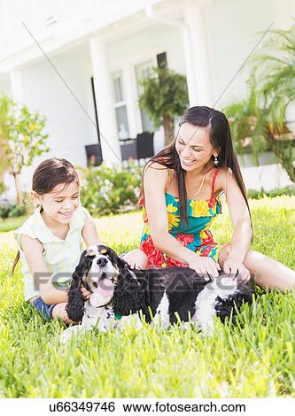 Girl (6-7) with mom and dog in backyard View Large Photo Image Stock Photograph - Girl (6-7) with mom and dog in backyard . Fotosearch
