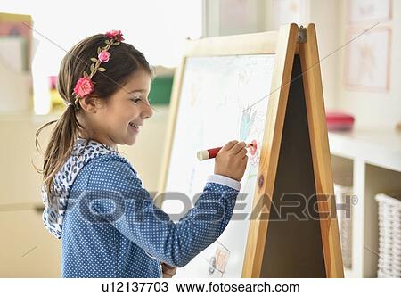 Girl (6-7) writing on board in classroom View Large Photo Image Stock Image - Girl (6-7) writing on board in classroom. Fotosearch