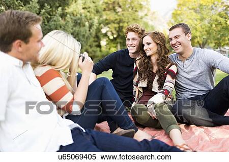 Group of friends taking photos in park View Large Photo Image Stock Photography - Group of friends taking photos in park. Fotosearch