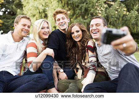 Stock Image - Group of friends taking selfie. Fotosearch