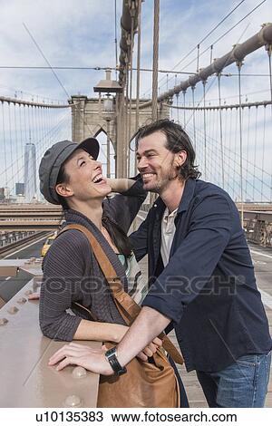 Stock Image - Happy couple flirting on Brooklyn Bridge . Fotosearch