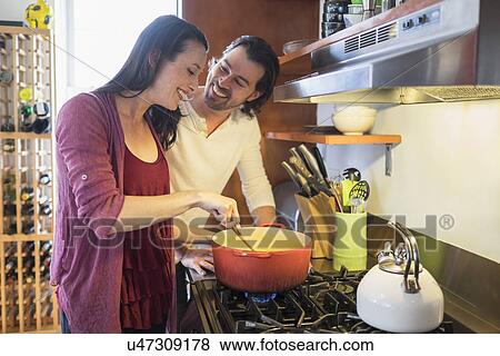 Happy couple preparing dinner View Large Photo Image Stock Photo - Happy couple preparing dinner. Fotosearch