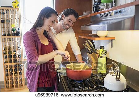 Happy couple preparing dinner View Large Photo Image Stock Photograph - Happy couple preparing dinner. Fotosearch