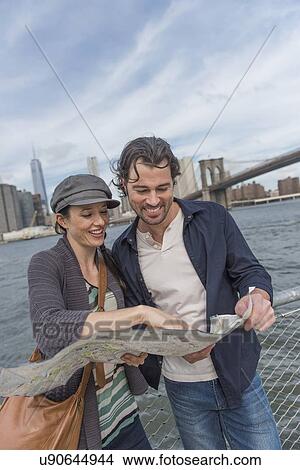 Happy couple reading map View Large Photo Image Picture - Happy couple reading map. Fotosearch