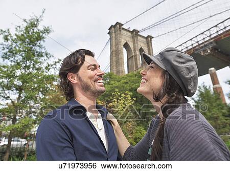 Happy couple standing against Brooklyn Bridge View Large Photo Image Stock Photograph - Happy couple standing against Brooklyn Bridge. Fotosearch