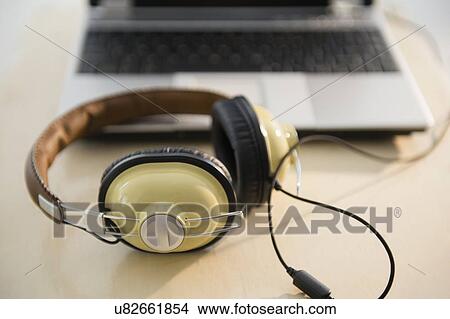 Picture - Headphones and laptop on table. Fotosearch