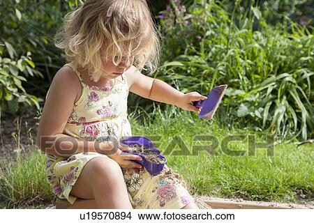 Picture - Little girl (2-3) playing in sandbox. Fotosearch