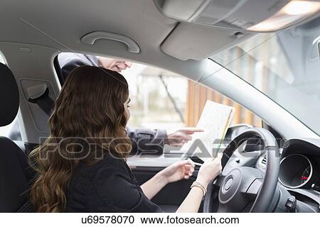 Man giving directions to young woman in car View Large Photo Image Stock Image - Man giving directions to young woman in car. Fotosearch