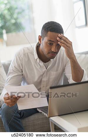 Stock Image - Man paying bills online. Fotosearch