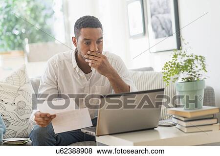 Stock Photo - Man paying bills online. Fotosearch