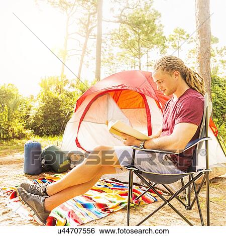Man reading book in front of tent View Large Photo Image Stock Photograph - Man reading book in front of tent. Fotosearch