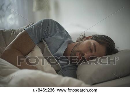 Man sleeping in bed View Large Photo Image Stock Photograph - Man sleeping in bed. Fotosearch