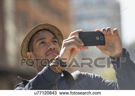 Stock Image - Man taking photo on street . Fotosearch