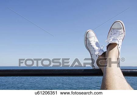 Stock Image - Man's feet on ferry boat. Fotosearch