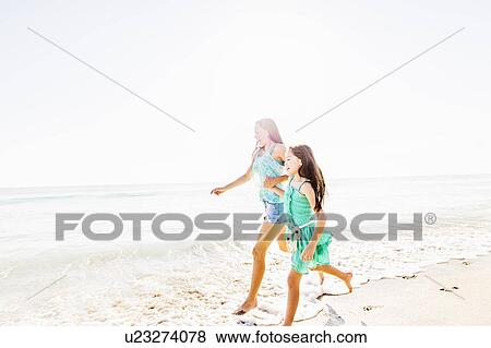 Mom and daughter (6-7) spending time together on beach View Large Photo Image Stock Photo - Mom and daughter (6-7) spending time together on beach. Fotosearch