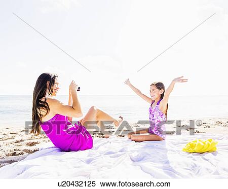 Mom taking picture of her daughter (6-7) on beach View Large Photo Image Stock Photography - Mom taking picture of her daughter (6-7) on beach. Fotosearch