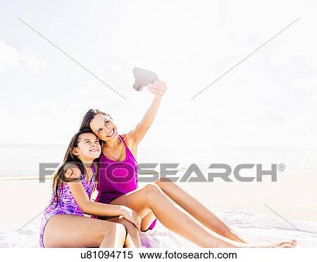 Mom taking picture with her daughter (6-7) on beach View Large Photo Image Stock Photography - Mom taking picture with her daughter (6-7) on beach. Fotosearch