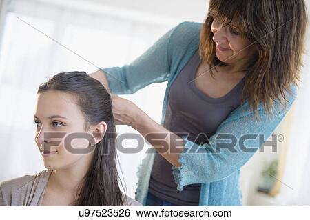 Mom tying up daughter's (14-15) hair View Large Photo Image Stock Photograph - Mom tying up daughter's (14-15) hair. Fotosearch