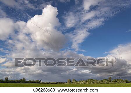 Moody sky above green meadow View Large Photo Image Stock Image - Moody sky above green meadow. Fotosearch
