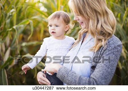 Mother and daughter (12-17 months) in corn field View Large Photo Image Stock Photo - Mother and daughter (12-17 months) in corn field. Fotosearch