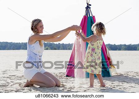 Mother playing with daughter (2-3) at sandy beach View Large Photo Image Stock Image - Mother playing with daughter (2-3) at sandy beach. Fotosearch