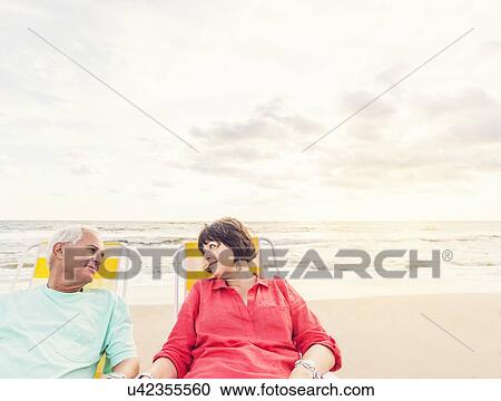 Older couple relaxing on beach View Large Photo Image Stock Image - Older couple relaxing on beach. Fotosearch