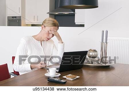 Stock Photo - Overworked woman holding pack of tablets. Fotosearch