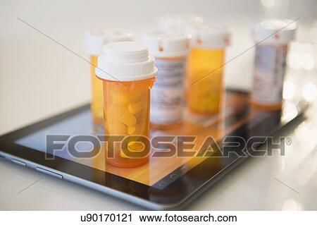 Pill containers on digital tablet View Large Photo Image Stock Image - Pill containers on digital tablet. Fotosearch