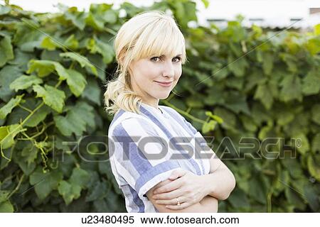 Stock Photography - Portrait of blond woman in back yard. Fotosearch
