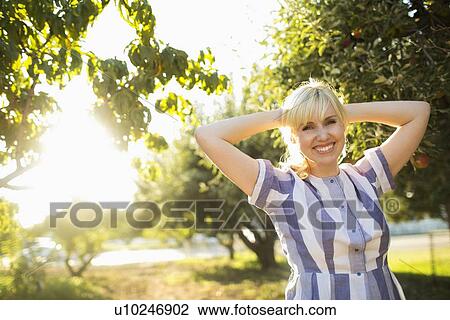 Portrait of blond woman in orchard View Large Photo Image Stock Image - Portrait of blond woman in orchard. Fotosearch