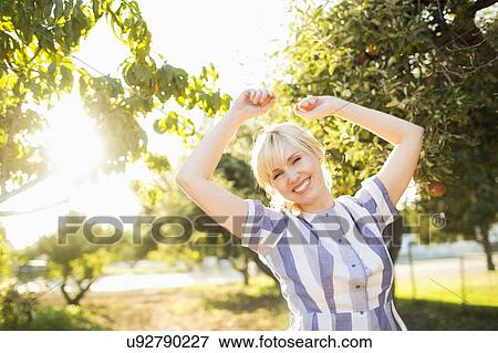Portrait of blond woman in orchard View Large Photo Image Stock Photo - Portrait of blond woman in orchard. Fotosearch