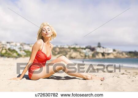 Stock Image - Portrait of blond woman on beach. Fotosearch