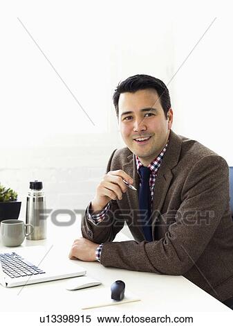 Stock Photography - Portrait of businessman sitting in office. Fotosearch