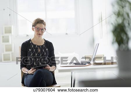 Picture - Portrait of businesswoman using digital tablet in office. Fotosearch