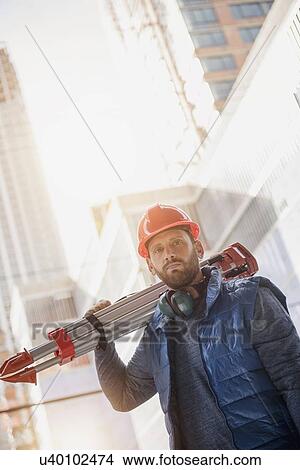 Portrait of construction worker carrying tripod on shoulder View Large Photo Image Picture - Portrait of construction worker carrying tripod on shoulder. Fotosearch