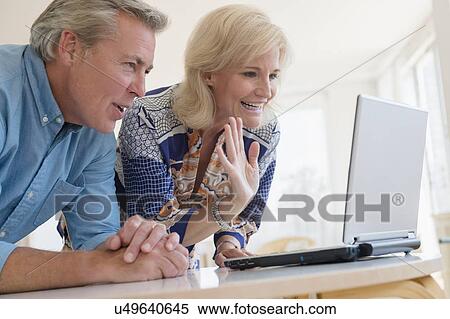 Portrait of couple looking at laptop screen View Large Photo Image Stock Photography - Portrait of couple looking at laptop screen. Fotosearch
