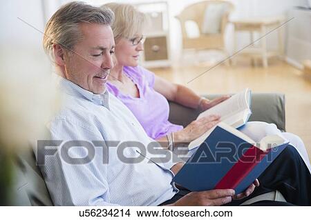 Portrait of couple sitting on sofa reading books View Large Photo Image Picture - Portrait of couple sitting on sofa reading books. Fotosearch