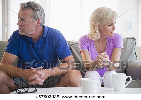 Portrait of couple sitting on sofa, looking away from each other View Large Photo Image Stock Photography - Portrait of couple sitting on sofa, looking away from each other. Fotosearch