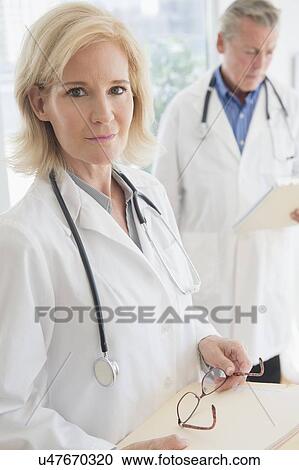 Portrait of female doctor holding clipboard and eyeglasses View Large Photo Image Stock Image - Portrait of female doctor holding clipboard and eyeglasses. Fotosearch