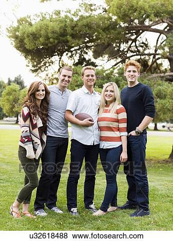 Portrait of friends with football in park View Large Photo Image Stock Photo - Portrait of friends with football in park. Fotosearch