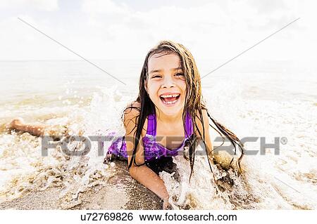 Portrait of girl (6-7) lying in sand on beach View Large Photo Image Stock Photograph - Portrait of girl (6-7) lying in sand on beach. Fotosearch