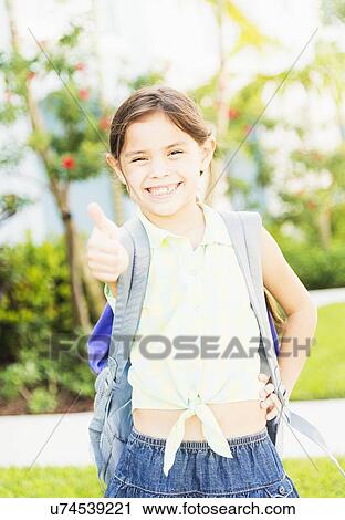 Stock Image - Portrait of girl (6-7) with thumbs up. Fotosearch
