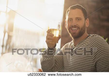 Portrait of man having drink in bar View Large Photo Image Stock Image - Portrait of man having drink in bar. Fotosearch