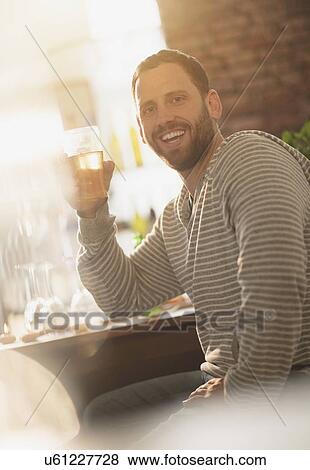 Portrait of man having drink in bar View Large Photo Image Stock Photo - Portrait of man having drink in bar. Fotosearch