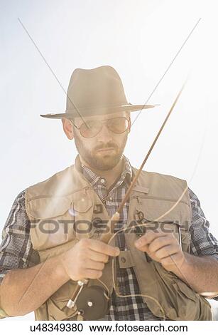 Stock Image - Portrait of man holding fishing rod. Fotosearch