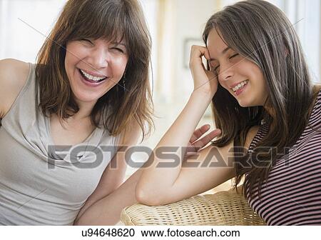 Stock Image - Portrait of mom and teenage girl (14-15) laughing at home. Fotosearch