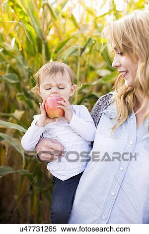 Stock Photography - Portrait of mother and daughter (12-17 months) in field. Fotosearch