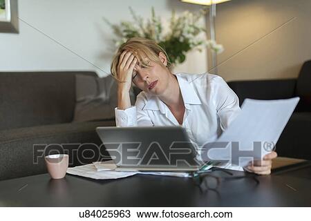 Stock Image - Portrait of overworked woman using computer. Fotosearch